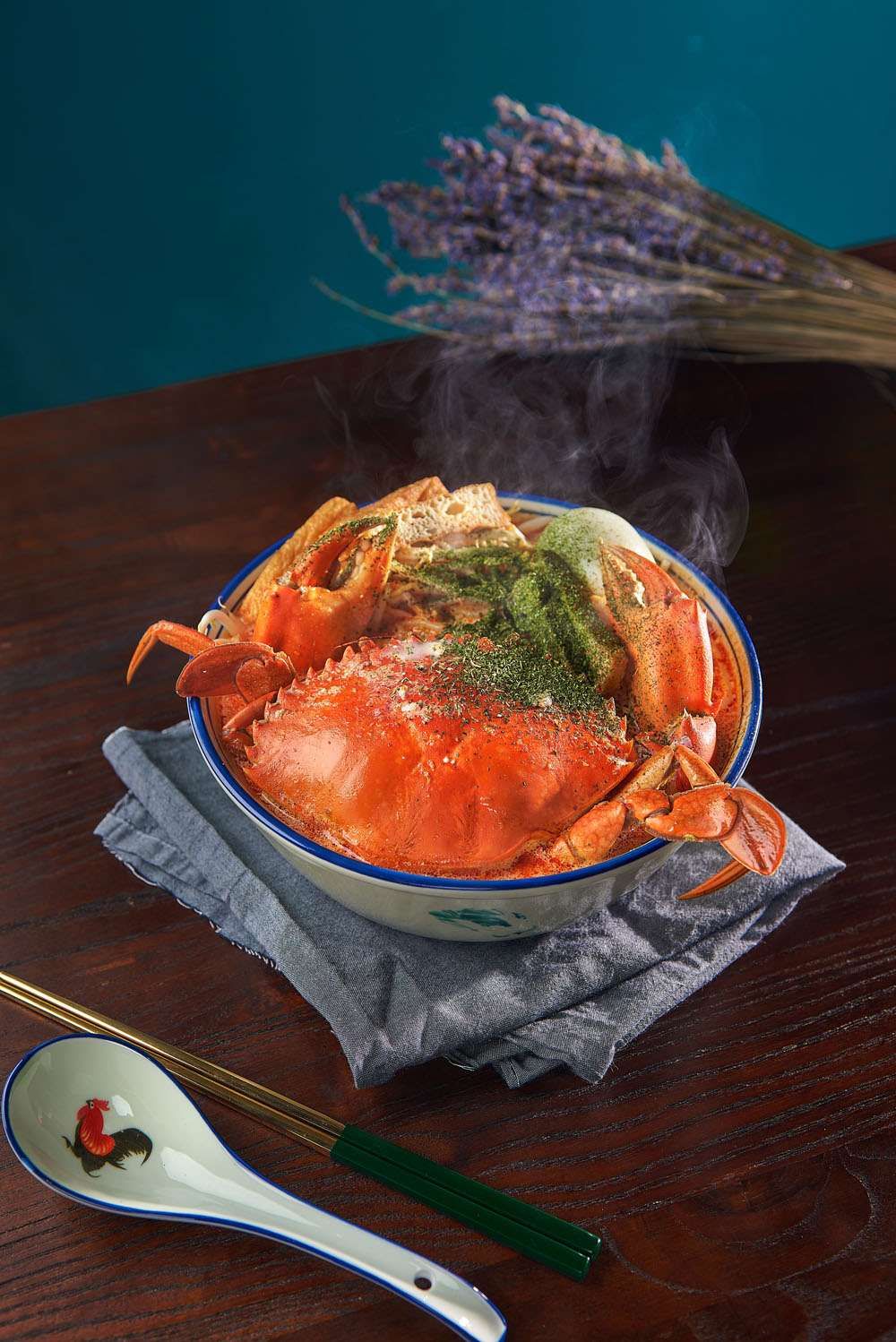 Crab Laksa Bee Hoon: a whole crab in a rich orange laksa broth with bee hoon in a blue-rimmed bowl